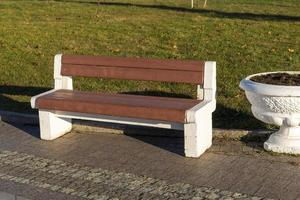 Stylish bench in a summer Park made of concrete and wood. photo