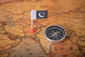Flag of Pakistan and compass on the world map. photo
