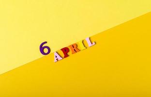 Wooden letters of the sixth of April on a yellow background. photo