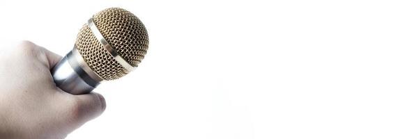 A man's hand holds a microphone on a white background. Copy Space. photo