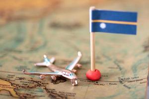 la bandera de nauru y el avión en el mapa mundial. foto