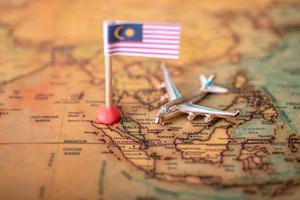 The flag of Malaysia and the plane on the world map. photo