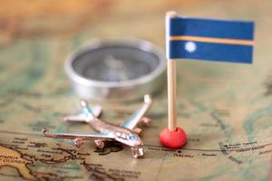 bandera nauru, avión y brújula en el mapa mundial. foto