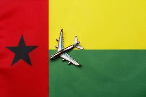 Plane over the flag of Guinea-Bissau, travel concept. photo