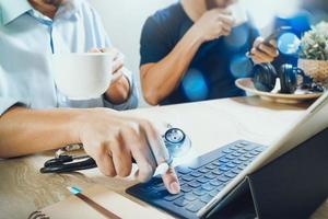 Medical doctor team taking coffee break.using digital tablet docking smart keyboard and smart phone on marble desk.listen music,filter film effect photo