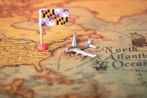 la bandera de maryland y el avión en el mapa del viejo mundo.