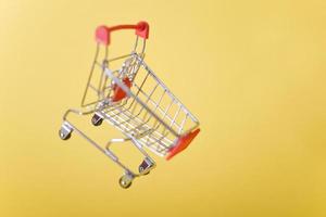 cart, hand-cart, shopping cart, trolley on a yellow background. concept buyer,Shopper. photo