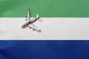 Plane over the flag of Sierra Leone, the concept of travel and tourism. photo