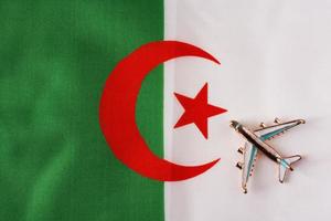 Plane over the flag of Algeria travel concept. photo