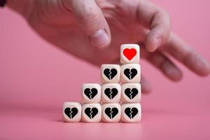 Love Valentine's Day conceptman hand takes the heart, with a pyramid of other broken hearts. photo