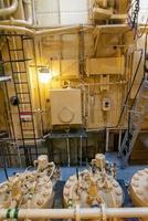 Yellow engine mounted on ship. Engine room on a old cargo boat ship. photo