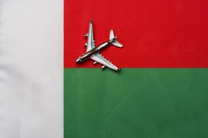 avión sobre la bandera de madagascar, el concepto de viajes y turismo. foto