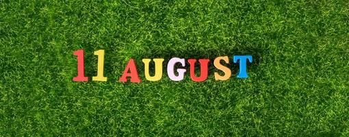 August 11. Image of wooden colored letters and numbers on August 11 against the background of a green lawn, mountain day in Japan. Summer day. photo