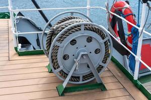 Bobbins with a rope on the deck of the ship close-up photo