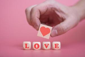 Love Valentine's Day conceptman hand holding heart, on pink background. photo