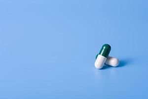 White-green capsules on a blue background to maintain health. photo