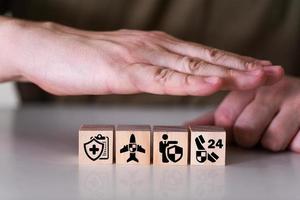 Insurance signs on wooden cubes, hands covering wooden cubes. photo