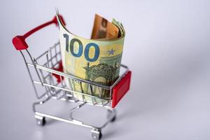 The supermarket cart is full of money. Euro in a shopping cart on a white background. photo