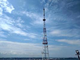 Telecommunication tower blue clouds on blue sky background photo