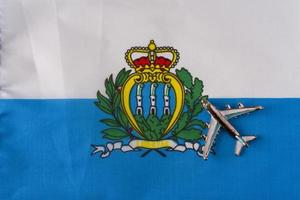 Airplane over San Marino flag travel concept. photo