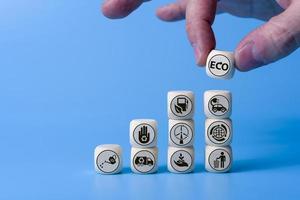 Ecology concept with icons on wooden cubes, blue background. photo