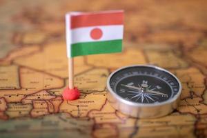 Niger flag and compass on the world map. photo