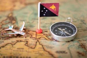 flag of Papua New Guinea, compass and airplane on the world map. photo