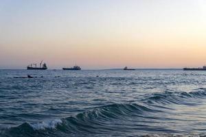 Cargo ships on the horizon of the Mediterranean sea. photo