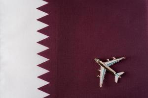 Plane over the flag of Qatar travel concept. photo