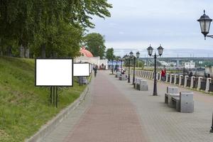 Blank billboard mock up, public information board with copy space on the street, near harbor. photo