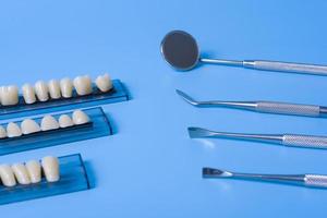 Teeth model with dental tools on blue background photo