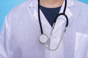 primer plano de un médico varón con un abrigo médico blanco y un estetoscopio con una camiseta. foto