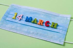 Wooden letters on March 14 on a medical mask. photo