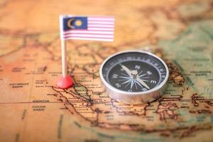 bandera de malasia y brújula en el mapa mundial. foto
