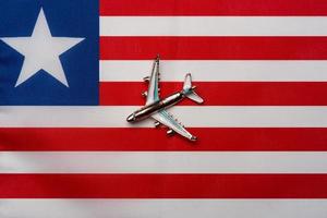 Airplane over Liberia flag island travel concept. Toy plane on a flag. photo