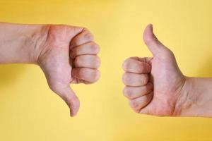 Likes and dislikes the hand gesture, a young male hand close-up. photo