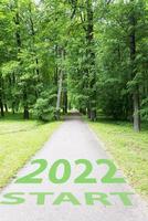 The concept of a road for business planning,the Word 2022, written on the road in the middle of trees in the park. photo