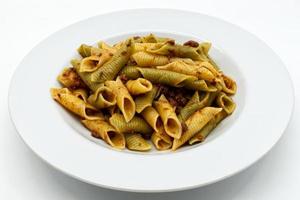 Italian Maccheroni al pettine al ragu. Colored pasta dish. photo