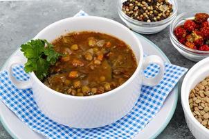 Vegetable soup with lentils in white plate. Studio Photo