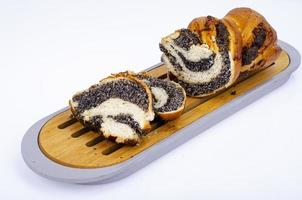Sliced loaf with poppy seeds on wooden tray. Homemade baking. Studio Photo
