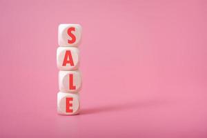 Word sale on wooden cubes, pink background, place for text. photo