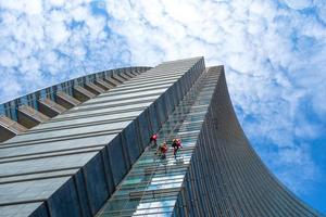 Milan, Italy - September 7 2018 Group of Alpinists in service for windows cleaning of skyscrapers buildings