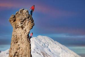 Male and female rock climbers with the lead that secures the partner photo