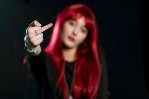 A girl with red hair does the middle finger