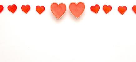 Two big romantic valentine hearts and several hearts on top on white background photo