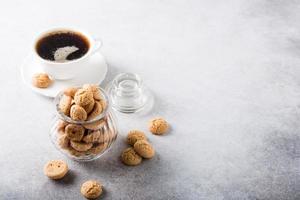 galletas amaretti con taza de café blanca foto