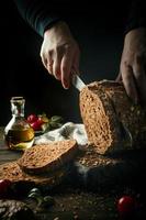 Female hands slicing homemade multigrain bread photo