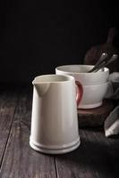 Ceramic white jug with red handle photo