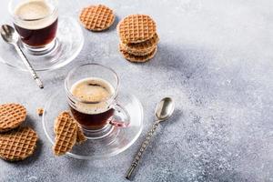 Glass cup of coffee with syrupwaffles cookies photo