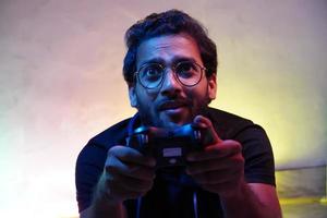 exited man using playing video game using gaming wireless joystick- gaming concept photo